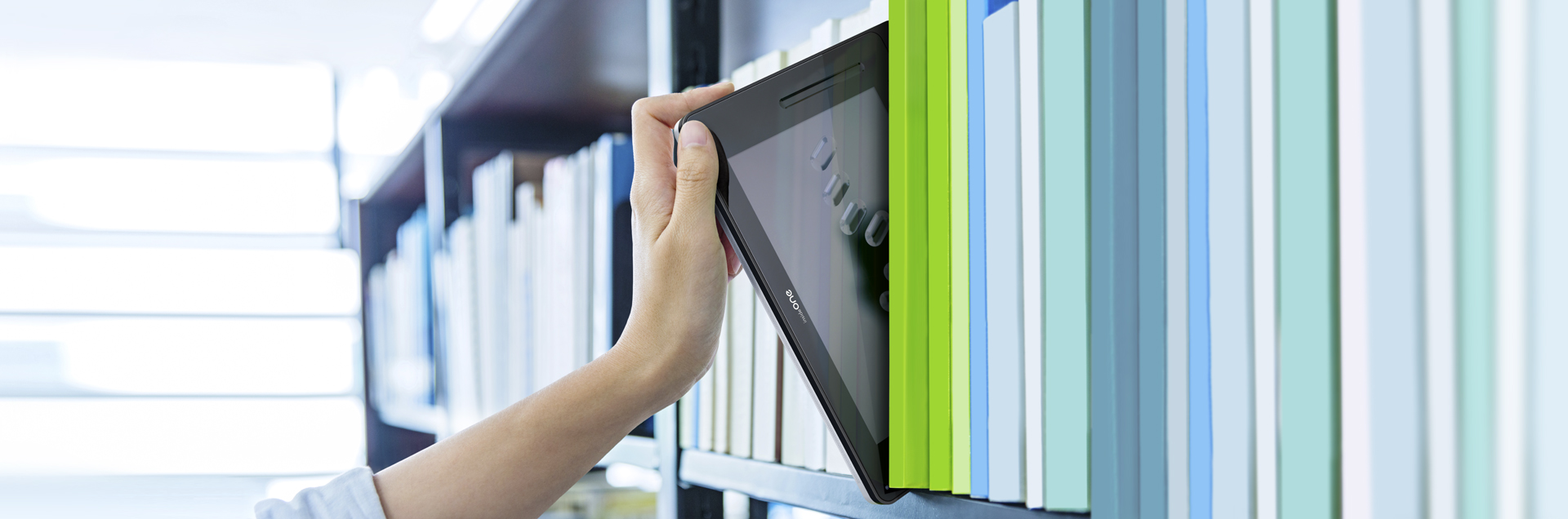 The picture shows the hand of a person taking insideONE like a book in a library.