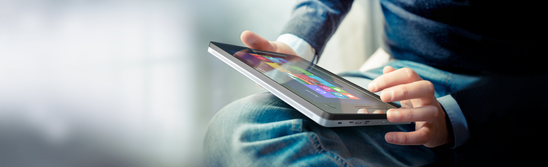 The picture shows a young man using the insideONE tablet on his lap.